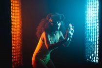 Mulher étnica surpreso anônimo com boca aberta explorando a realidade virtual em fone de ouvido em fundo preto — Fotografia de Stock