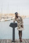 Elegante pensoso bella signora afroamericana con trecce africane sorridente guardando la fotocamera nel parco — Foto stock