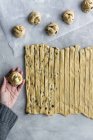 Dall'alto mano di raccolto di pasta fresca rotolante femminile irriconoscibile per pasticceria in cucina accogliente — Foto stock