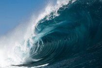 Potenti onde marine schiumose che rotolano e schizzano sulla superficie dell'acqua contro il cielo blu — Foto stock