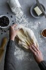 Dall'alto mano di raccolto di pasta fresca rotolante femminile irriconoscibile per pasticceria in cucina accogliente — Foto stock