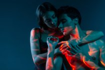 Imagem artística de casal afetuoso mostrando amor sob luzes projetor — Fotografia de Stock