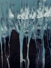 Dall'alto aerea paesaggio strutturato di ruvida riva sassosa irregolare e onde oceaniche schiumose con ruscelli — Foto stock