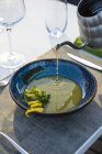 Официант наливает чечевичный суп в открытый ресторан высокой кухни — стоковое фото