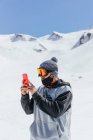 Unrecognizable male athlete in sports glasses taking photo of Sierra Nevada on cellphone in province of Granada Spain — Stock Photo