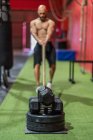 Blurred anonymous strong sportsman pulling rope with heavy weights during intense workout in contemporary gym — Stock Photo