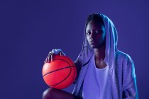 Black woman with basketball outfit in the studio using color gels and projector lights — Stock Photo