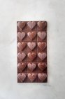 Vista dall'alto di deliziose caramelle al cioccolato con noci a forma di cuore su sfondo tavolo di marmo — Foto stock