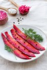 From above gravlax with mixed peppercorns and fresh dill sprigs on plate on light background — Stock Photo