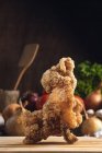 Смачна хрустка смажена курка, яку подають на дерев'яній обробній дошці на столі з різними овочами на кухні — стокове фото