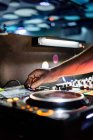 Обрізана невпізнавана людина, що використовує професійний двоканальний DJ контролер для виступів, включаючи музичну імпровізацію на концерті в сучасному нічному клубі — стокове фото