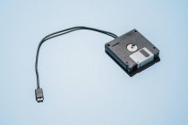 Зверху стопки чорних дискових дисків за допомогою кабелю USB, розміщеного на світло-блакитному фоні — стокове фото