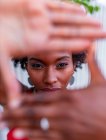 African American female demonstrating photo gesture with hands while looking at camera — Stock Photo