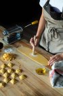 Pessoa irreconhecível preparando raviolis e massas em casa. Ela está pintando a massa com ovos — Fotografia de Stock