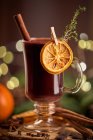 Gluhwein или рождественский пунш глинтвейна сервер глинтвейна на стеклянную кружку с сушеными апельсиновыми ломтиками — стоковое фото