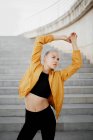 Young athletic caucasian woman stretching out outdoors near stairs — Stock Photo