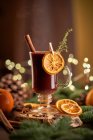 Gluhwein или рождественский пунш глинтвейна сервер глинтвейна на стеклянную кружку с сушеными апельсиновыми ломтиками — стоковое фото