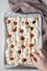 From above of anonymous person decorating dough for delicious focaccia with sun dried tomatoes — Stock Photo