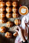 De cima mão com apetitoso fermento fresco sourdough pão cruz quente e caneca de café na mesa de madeira — Fotografia de Stock