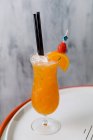 Стакан холодного коктейля из водки с соком апельсина и соломинкой со льдом — стоковое фото