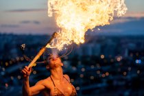 Жінка - пожежник, що здійснює вогонь на заході сонця — стокове фото