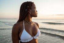 Vista laterale donna nera con trecce sulla spiaggia — Foto stock