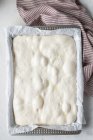 Vista dall'alto della pasta fatta in casa posta su carta da forno per cucinare il pane tradizionale — Foto stock