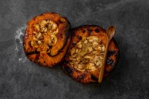 From above of tasty appetizing healthy baked pumpkin halves with seeds on gray table — Stock Photo