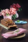 Ainda a vida de um bolo de esponja ao lado de vários vasos rosa com flores em uma mesa — Fotografia de Stock