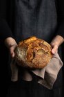 Unrecognizable crop chef in grembiule in piedi con pezzo di pane appena sfornato — Foto stock