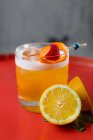 Kristallglas Amaretto Sour Cocktail garniert mit Orangenschale und Himbeere serviert mit halbierter Zitrone — Stockfoto