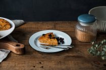De arriba pedazo de delicioso pastel de calabaza en el plato en la mesa de madera - foto de stock