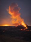 Живописный вид активного вулкана с горячей лавой на фоне облачного закатного неба в Исландии — стоковое фото