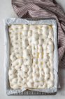 Vista dall'alto della pasta fatta in casa posta su carta da forno per cucinare il pane tradizionale — Foto stock