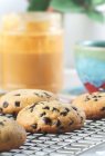 Bodegón de galletas fritas de chocolate recién hechas con mantequilla de maní y espolvoreos al lado de un café - foto de stock