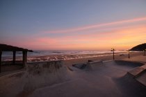 Malerischer Blick auf Skatepark am Sandstrand in der Nähe des Meeres unter Sonnenuntergang Himmel — Stockfoto