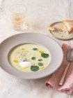 From above asparagus mascarpone cream soup near napkin and beverage on table — Stock Photo