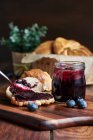Preparation of a breakfast of croissants with blueberry jam on a wooden table — Stock Photo