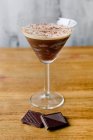 Verre de cocktail alcoolisé sucré fait de lait de liqueur d'espresso et de chocolat placé sur une table en bois — Photo de stock