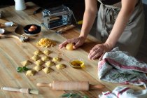 Persona irriconoscibile che prepara ravioli e pasta a casa. Sta plasmando la pasta. — Foto stock