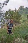 Высокий угол ходьбы мужчины-туриста по тропе в настроении во время похода летом — стоковое фото