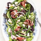 Dall'alto deliziosi prosciutto, mozzarella e insalata di asparagi su sfondo bianco — Foto stock