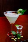 Verre en cristal de cocktail alcoolisé Margarita composé de liqueur d'orange tequila et de jus de citron vert servi avec du sel sur le bord du verre et de la feuille de menthe — Photo de stock