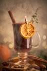 Serveur de vin paillé Gluhwein ou christmas punch sur une tasse en verre avec tranches d'orange séchées — Photo de stock