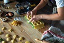 Pessoa irreconhecível preparando raviolis e massas em casa. Ela está montando os raviolis — Fotografia de Stock