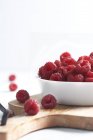 Side view of raspberries in a bowl on a wood isolated on a white background — Stock Photo