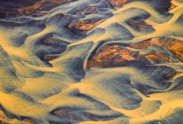 De cima vista aérea do rio com água laranja que flui através do campo áspero na Islândia — Fotografia de Stock