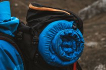 Seitenansicht der ruhigen anonymen Frau in hellblauer Jacke mit Rucksack, die auf einem felsigen Hügel steht — Stockfoto
