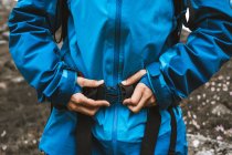 Кроп женщина путешествует в удобной синей куртке и крепеж кнопку рюкзак — стоковое фото