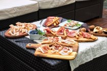 Dall'alto gustosi antipasti assortiti serviti sul tavolo con tovaglia in terrazza — Foto stock